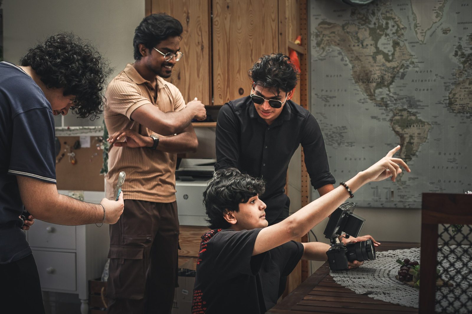 A student director blocks a scene with two actors while the crew watches