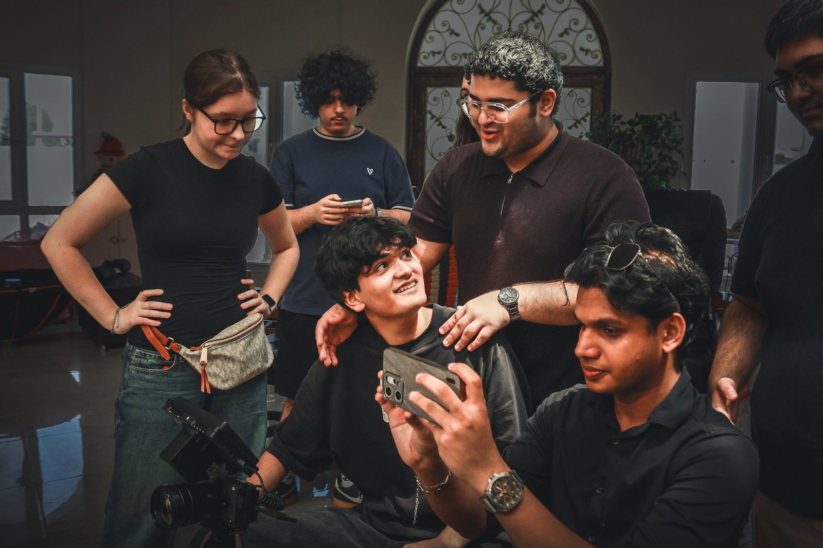 Crew gather around a phone to review a shot