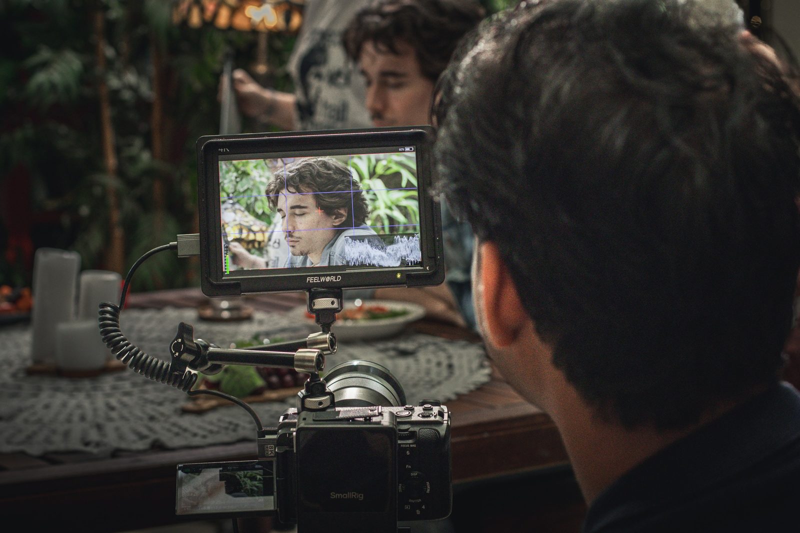 Director watches the monitor as a scene plays on the Szerelem teaser set