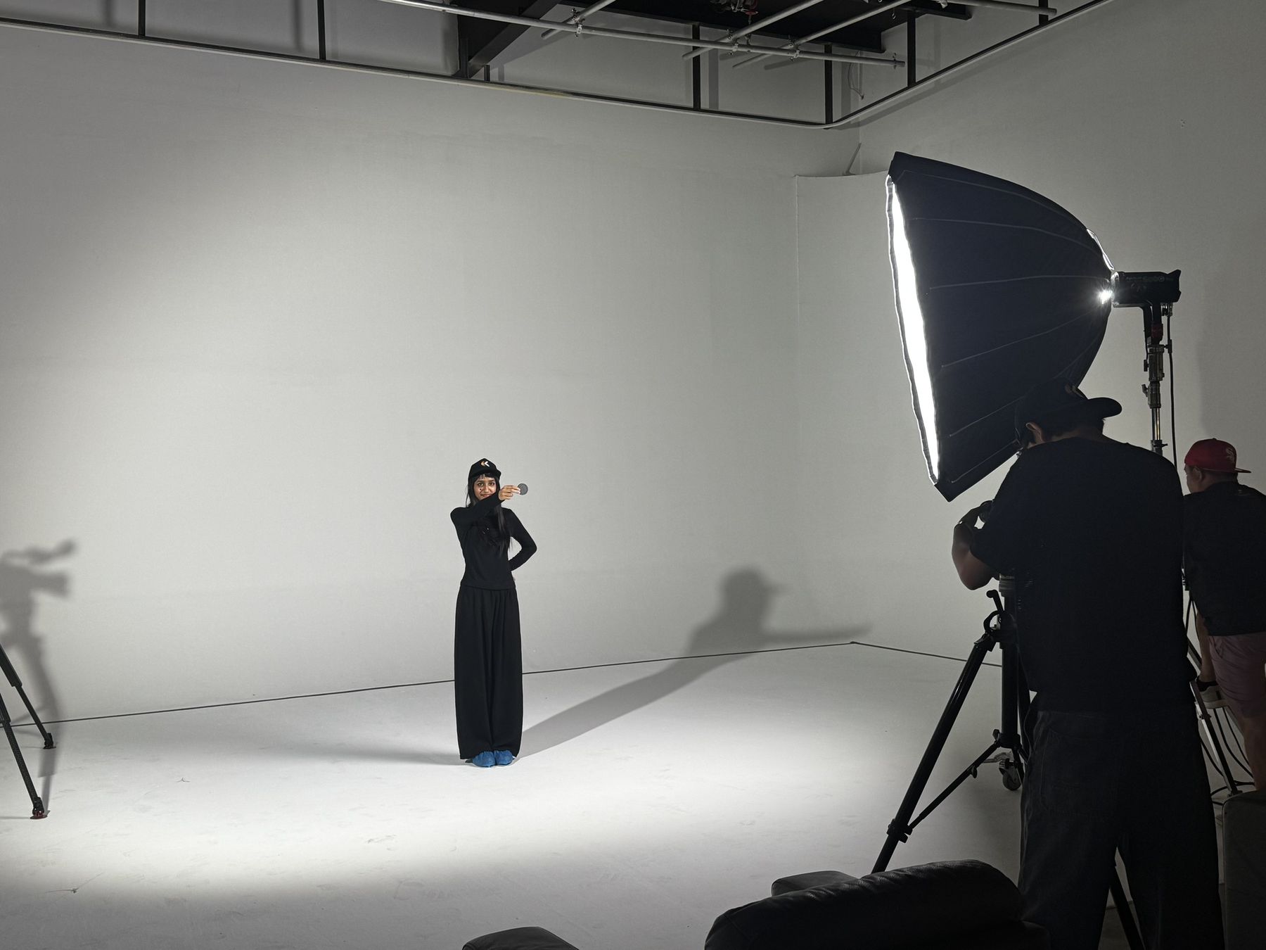 An actor stands alone on a white cyclorama under a softbox